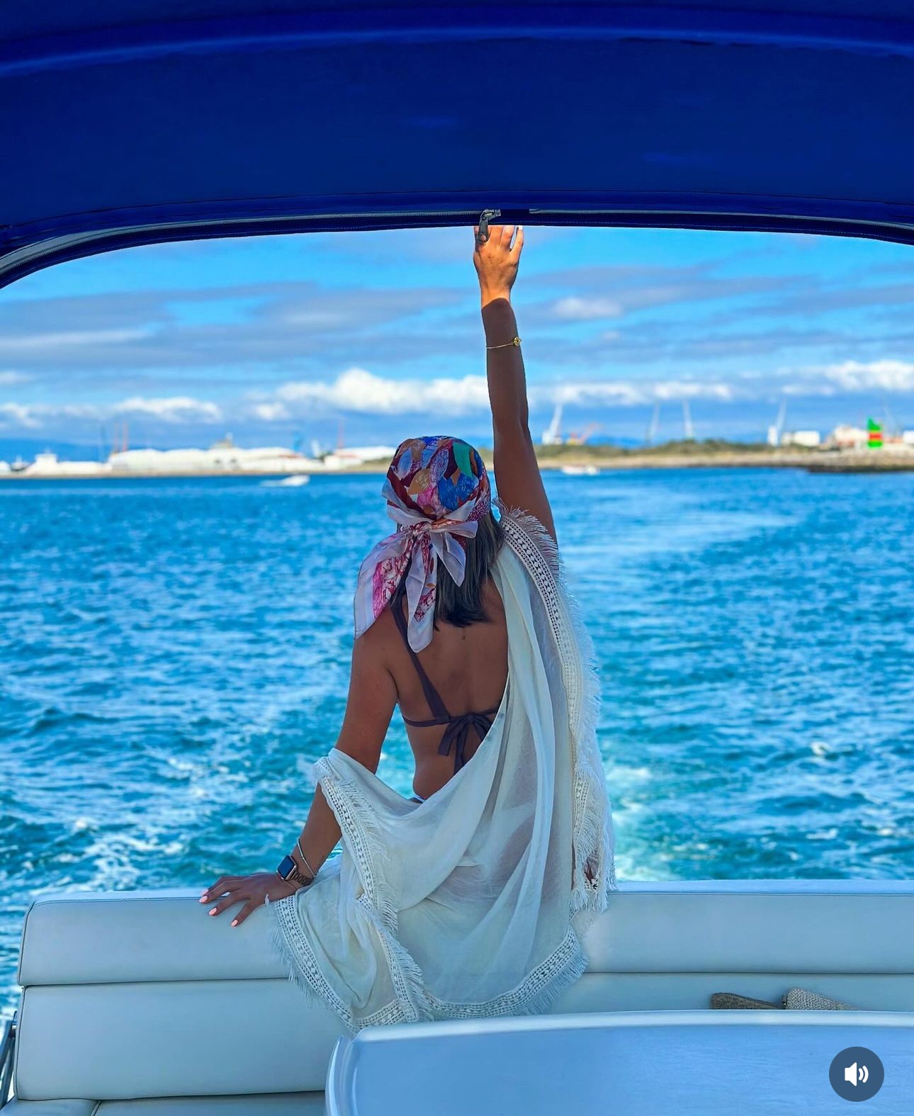 rapariga com os braços levantados a fazer um brinde a bordo da embarcação da Aveiro Boat Experience